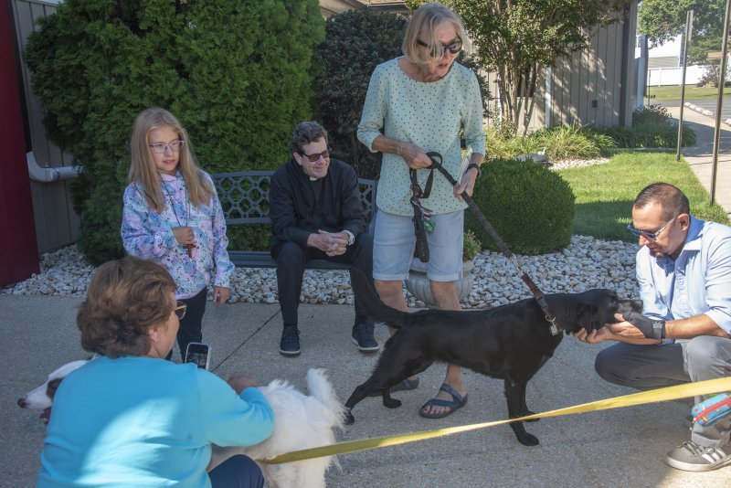 A group gathers for a blessing and fellowship at Lutheran Church of Our Savior. Shown are (l-r) Shea Brennan, Pastor Tad Thayer, Marianne Hoffman with Corbi, and Matt Brennan.